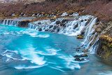 Rustgevende cascade in helder blauw water